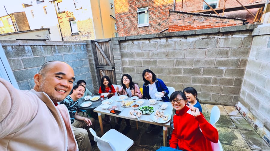 利物浦幸福的鸡饭聚餐 (一群大人和小孩在英国某个居家小院子户外聚餐的合照)