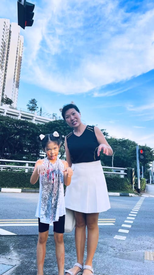 万圣节涂鸦证据 (穿黑色上衣和白裙的女士与穿白T恤的女孩站在城市街头，两人貌似化上万圣节的妆，背景中红灯亮着，还有大楼和绿树)